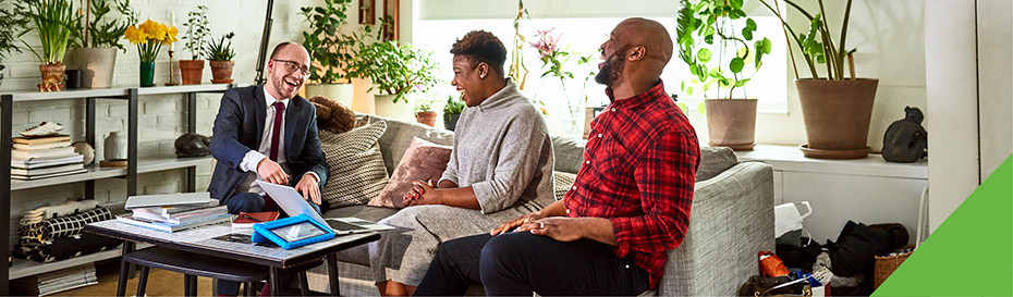 three people laughing while viewing a laptop