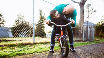 Father helping son learn to ride a bike